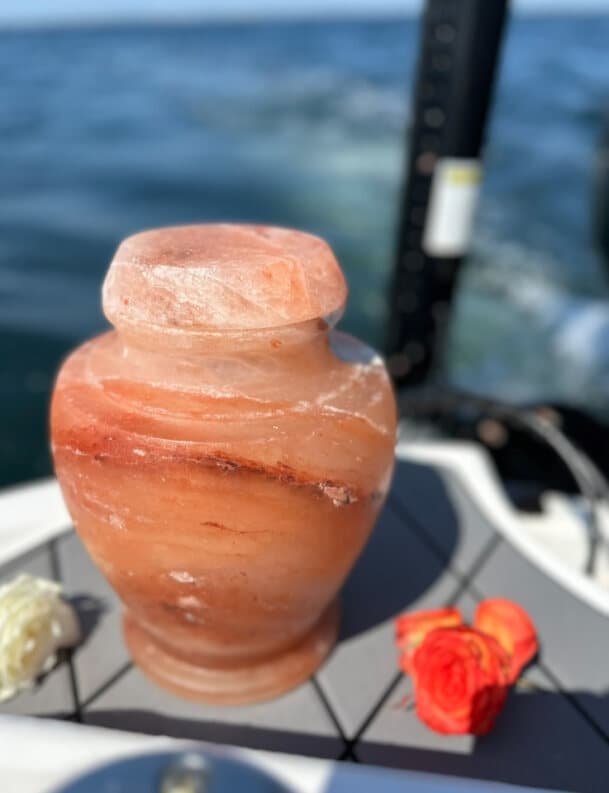 Pink Himalayan salt urn with roses on the boat deck at sea