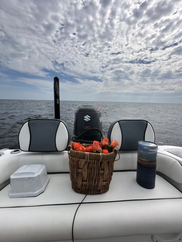 Orange rose basket with urns on the boat deck beneath a cloudy sky