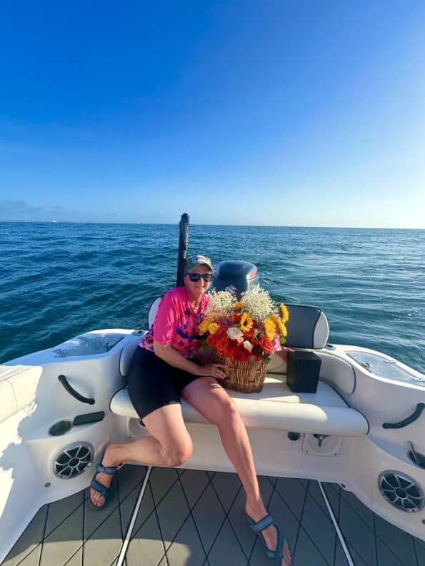 Family member holding a colorful flower basket aboard the vessel