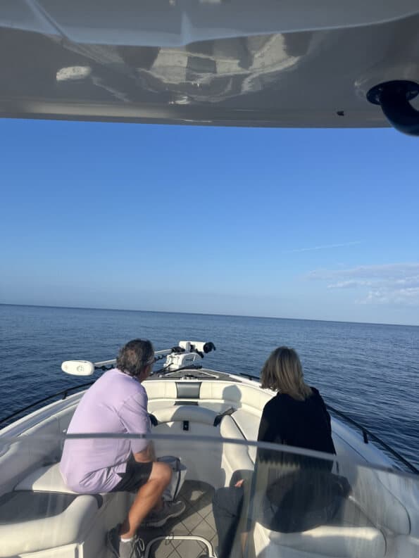 Guests seated on the bow looking out over a calm open ocean